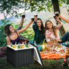 Black 10-gallon storage cooler with removable lid, used as a side table during a picnic for outdoor activities.