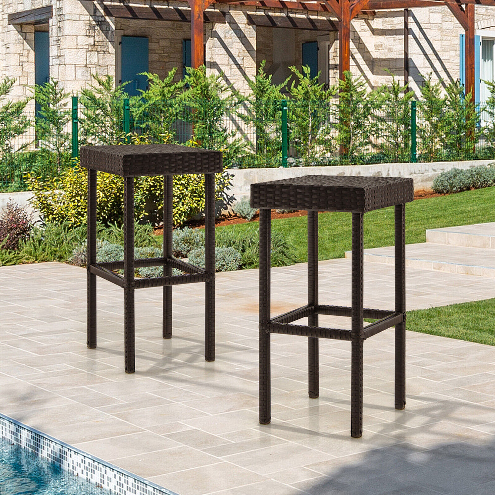 Two brown patio rattan wicker bar stools with footrests, perfect for outdoor use by the poolside or backyard.