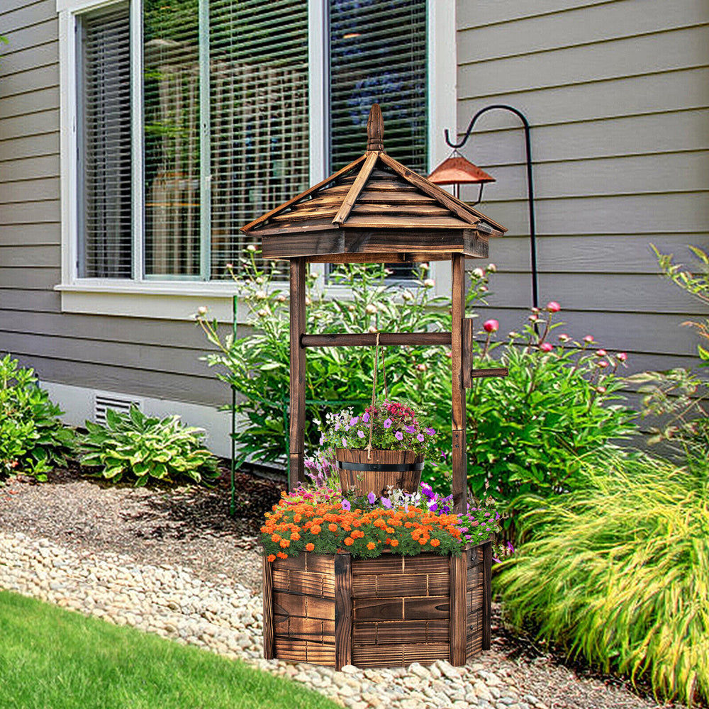 Rustic wooden wishing well planter with adjustable bucket, made from carbonized fir wood, perfect for garden or patio.