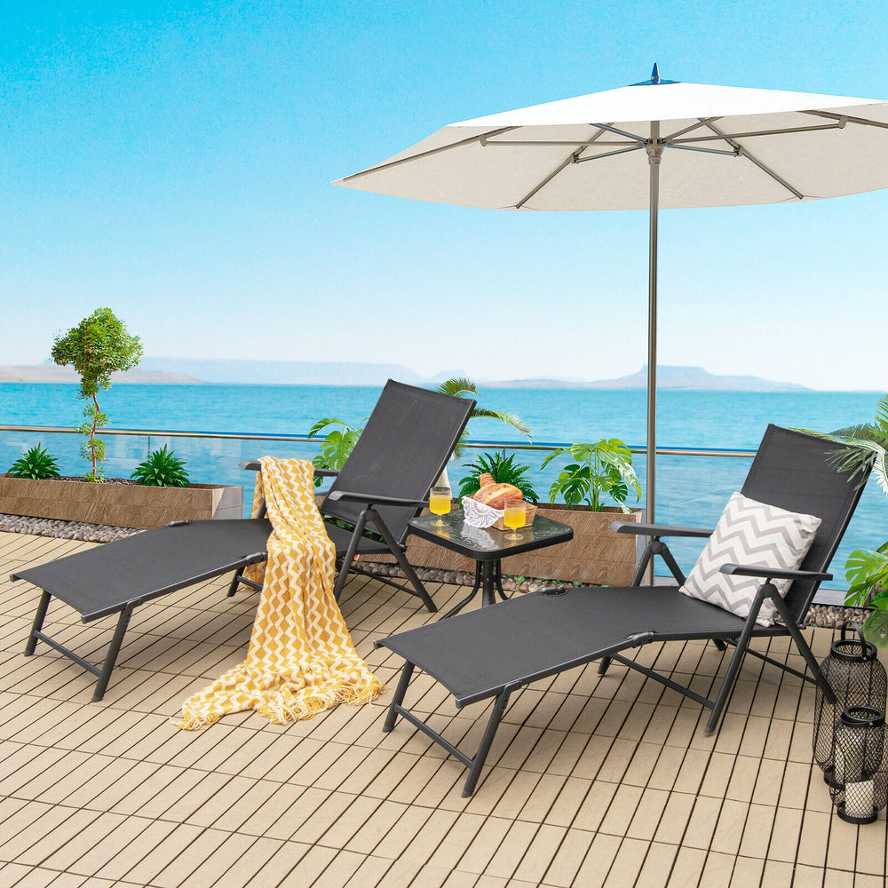 Two black foldable chaise lounge chairs with adjustable footrests, perfect for poolside relaxation or outdoor use.