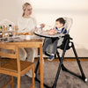 4-in-1 baby high chair in gray with adjustable height, removable trays, and rolling wheels for easy movement.