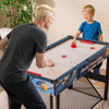 Child and adult playing air hockey on the 10-in-1 combo game table set, featuring a sturdy design and compact size.
