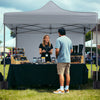Pop-up canopy tent with gray fabric and removable sidewalls, ideal for outdoor events and markets.