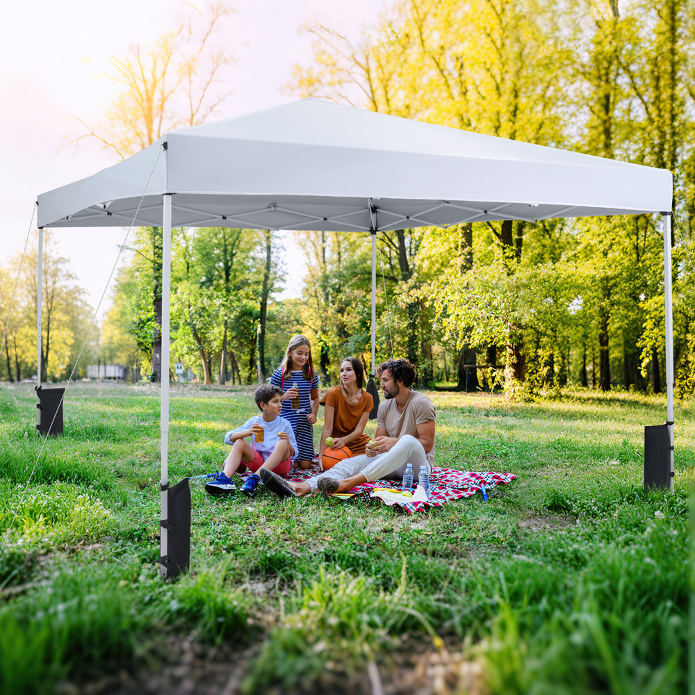10 x 10 feet pop-up canopy tent in white, set up for a family picnic, featuring UPF50+ sun protection and stability.