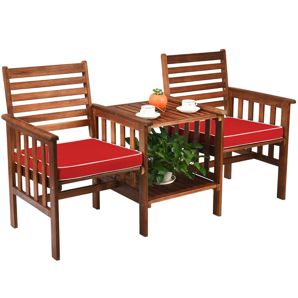 Acacia wood coffee table with umbrella hole and lower shelf, designed for outdoor patio use with a stylish red cushion.