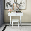 Elliptical lighted mirror on a white vanity table with two drawers and a cushioned stool for comfortable makeup.