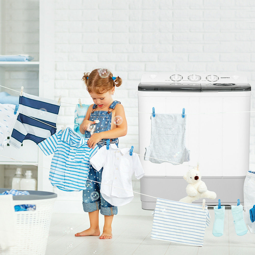 Child hanging clothes near a 2-in-1 portable washing machine, showcasing its compact design and versatile washing.