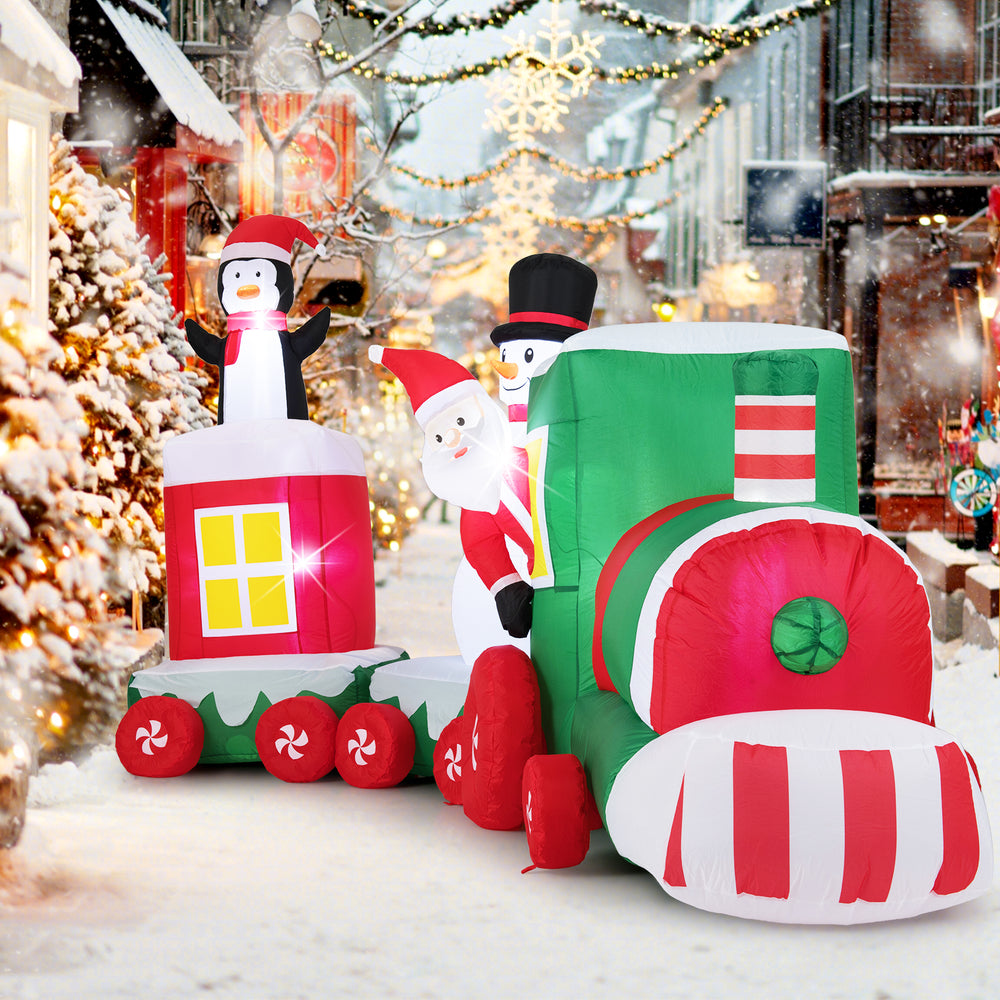 Christmas inflatable train featuring Santa Claus, a snowman, and a penguin, perfect for outdoor holiday displays.