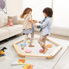 Kids playing on a 12-piece wooden balance beam set with colorful stepping stones, promoting creativity and balance.