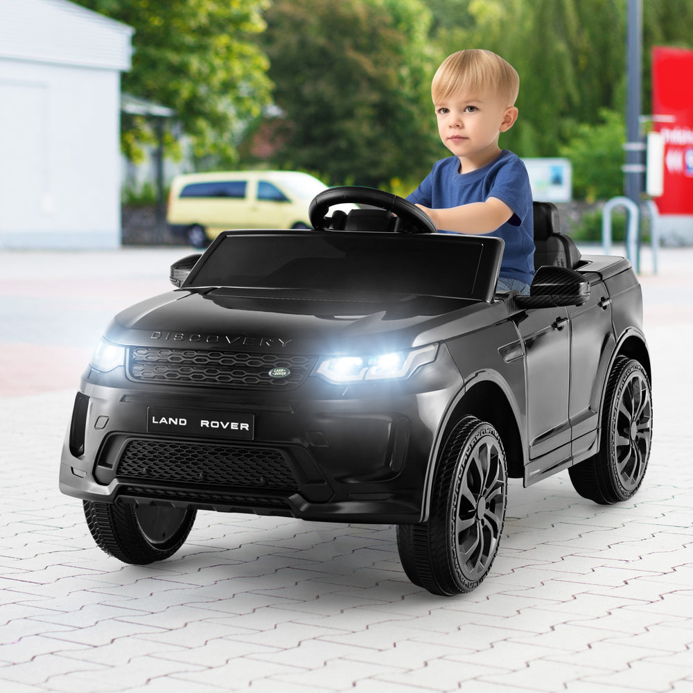 Kids ride-on Land Rover car in black with LED lights, remote control, and lockable doors for safe outdoor fun.