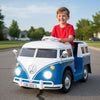 Child driving the blue licensed Volkswagen ride-on bus with LED headlights, foot pedal, and safe seat for outdoor fun.