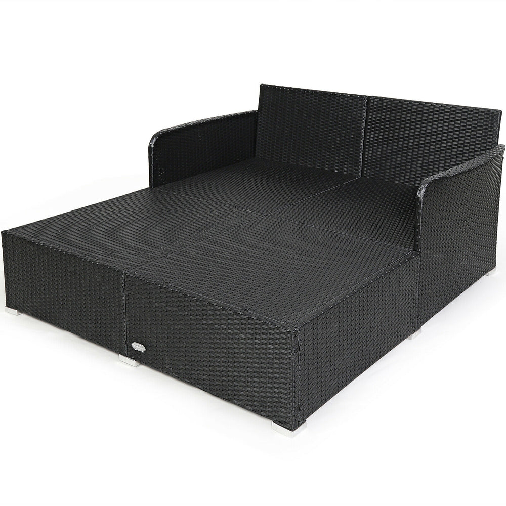 Spacious outdoor rattan daybed with upholstered cushions, featuring armrests and a curved backrest for comfort.
