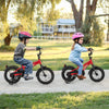 Two kids riding 12-inch adjustable bikes with training wheels, featuring reflectors and a bell for safety and fun.