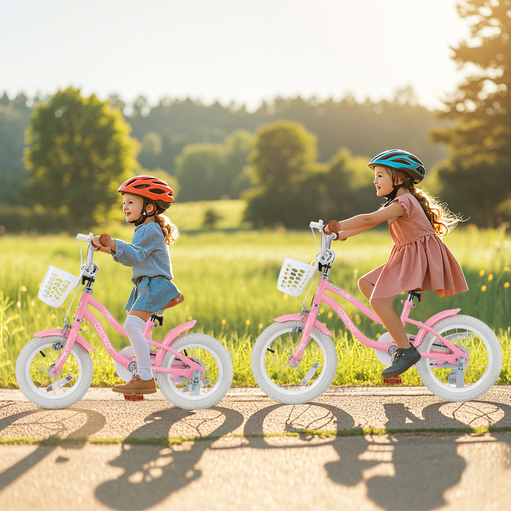Two girls riding 12-inch pink kids bikes with training wheels and baskets, enjoying a sunny day outdoors.