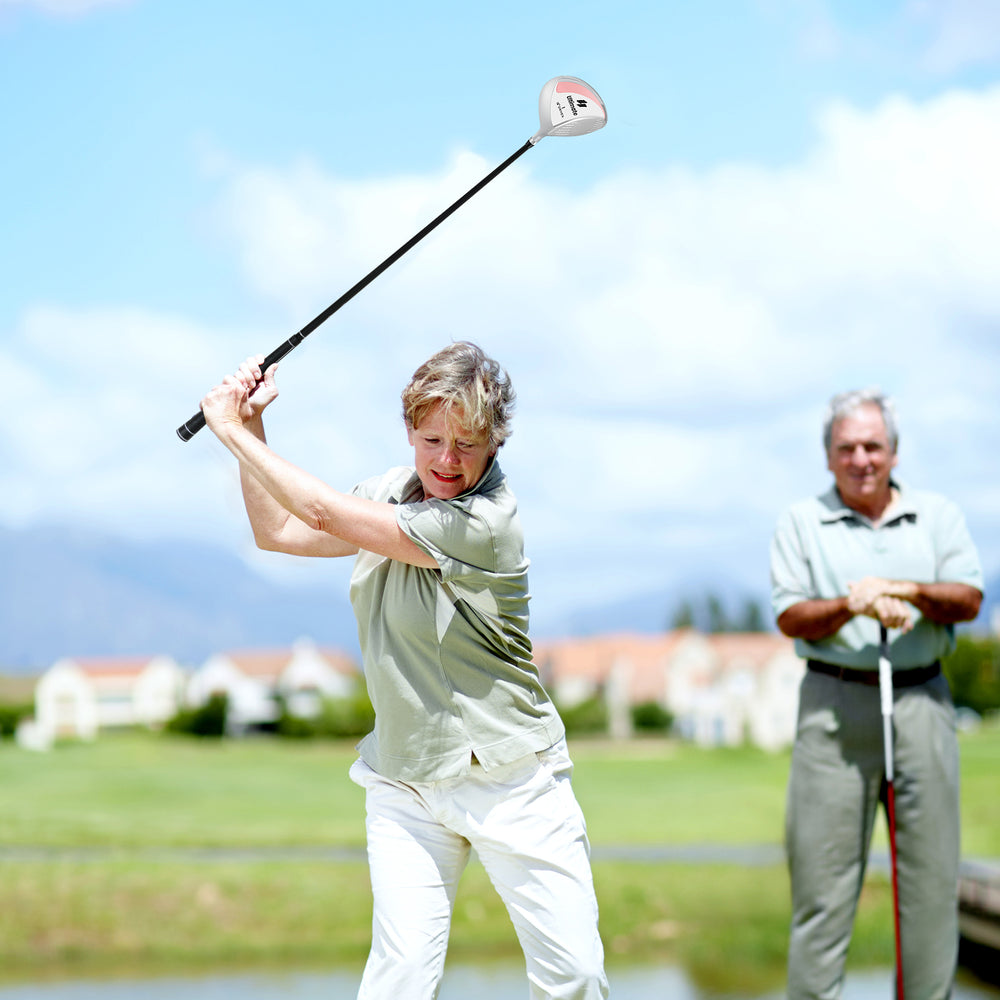 A woman swinging a 12° Individual Driver Golf Club for Women with a lightweight graphite shaft on a golf course.