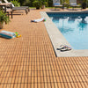 Acacia wood interlocking deck tiles arranged around a pool, showcasing natural beauty and easy assembly for outdoor use.