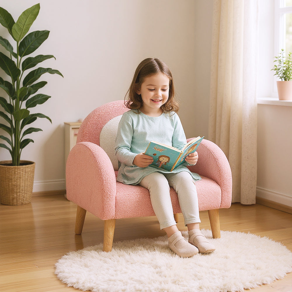 Kids armchair in pink with comfy backrest and armrests, covered in soft teddy fleece, perfect for reading in a cozy.