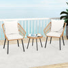 Two beige patio chairs with soft cushions and a round glass-top table, perfect for outdoor relaxation.