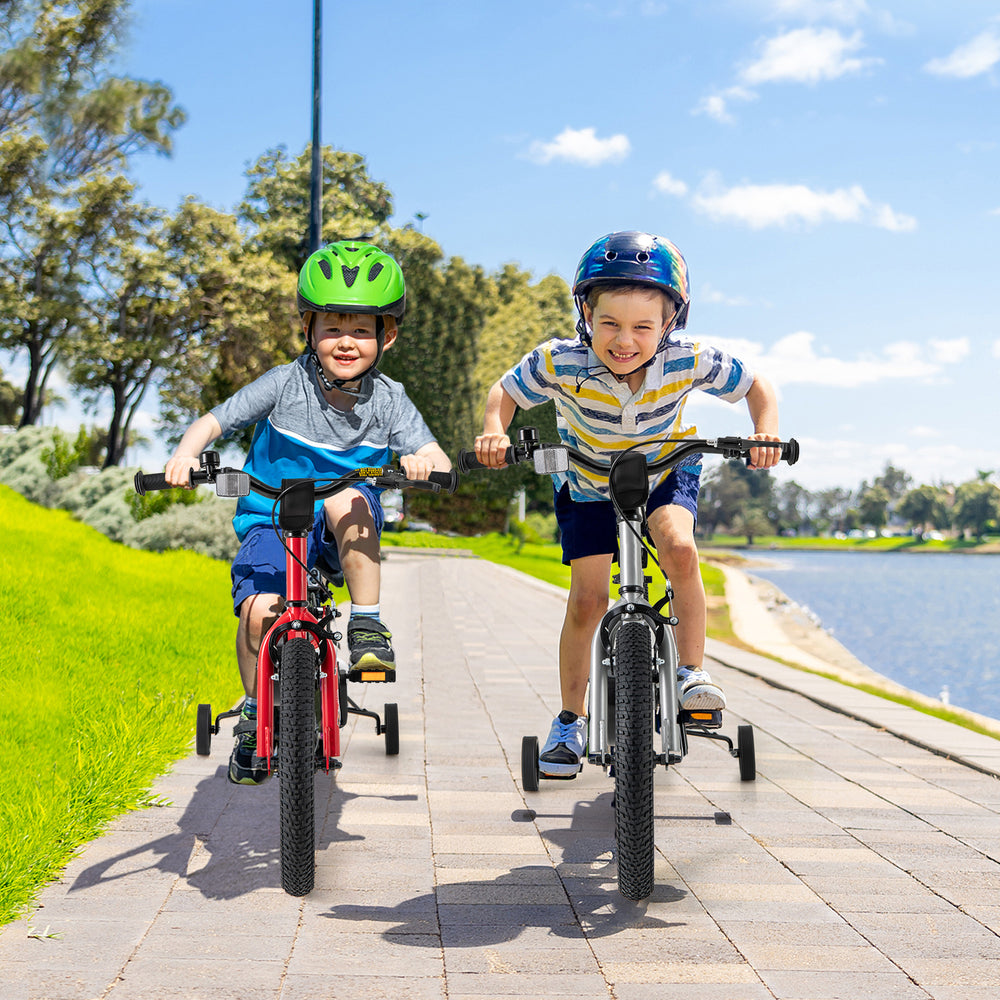 Two kids riding 16-inch bikes with training wheels, featuring handbrake and coaster brake, on a sunny pathway.