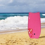 Bright pink lightweight bodyboard with EPS core and leash, perfect for outdoor surfing on the beach.