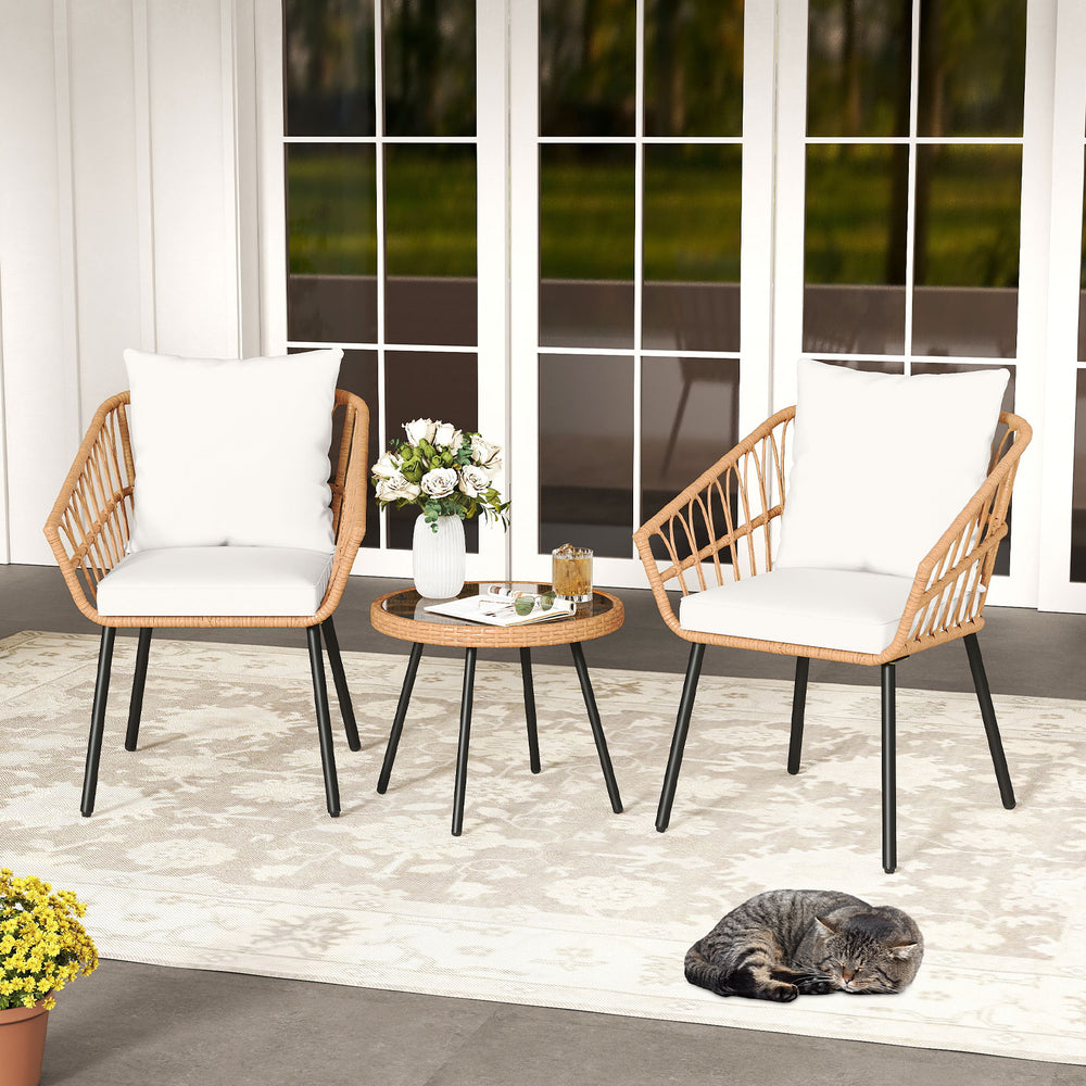 Two beige patio chairs with soft cushions and a glass top table, perfect for outdoor relaxation on a porch or patio.