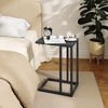 C-shaped side table in dark gray with a spacious tabletop, perfect for snacks and drinks beside a bed or couch.