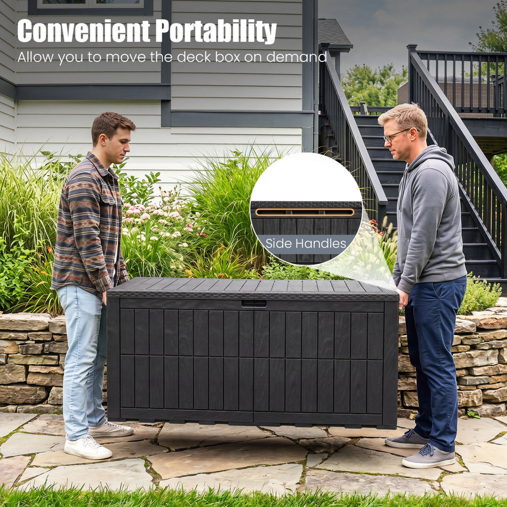Two men lifting the 180 Gal black outdoor deck box with side handles for convenient portability and storage.