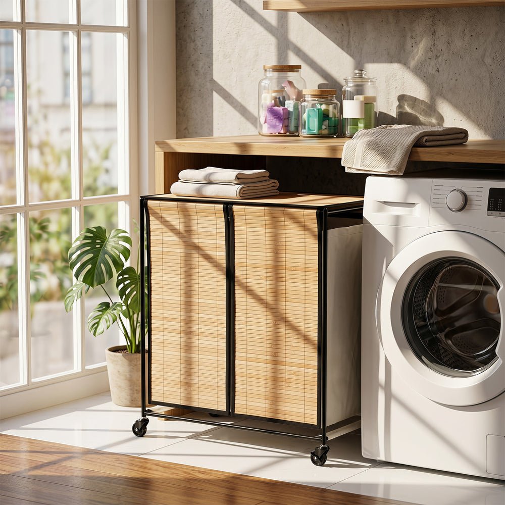 Natural 2-section laundry hamper with lid, bamboo slats, and lockable wheels for easy sorting and mobility.