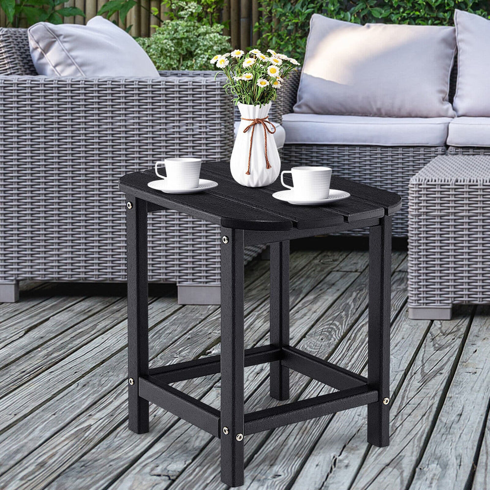 Black 18-inch weather-resistant side table made of HDPE, perfect for outdoor use with Adirondack chairs on patio.