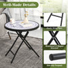 Round gray folding side table with tempered glass top and reinforced X-shaped metal frame for indoor and outdoor use.