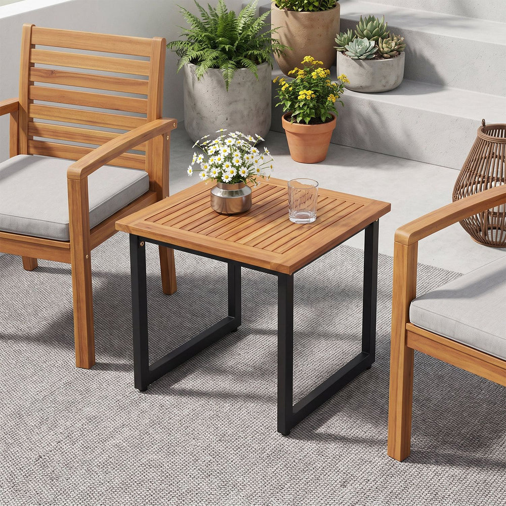 Square acacia wood patio side table with slatted top and powder-coated metal frame, perfect for outdoor relaxation.