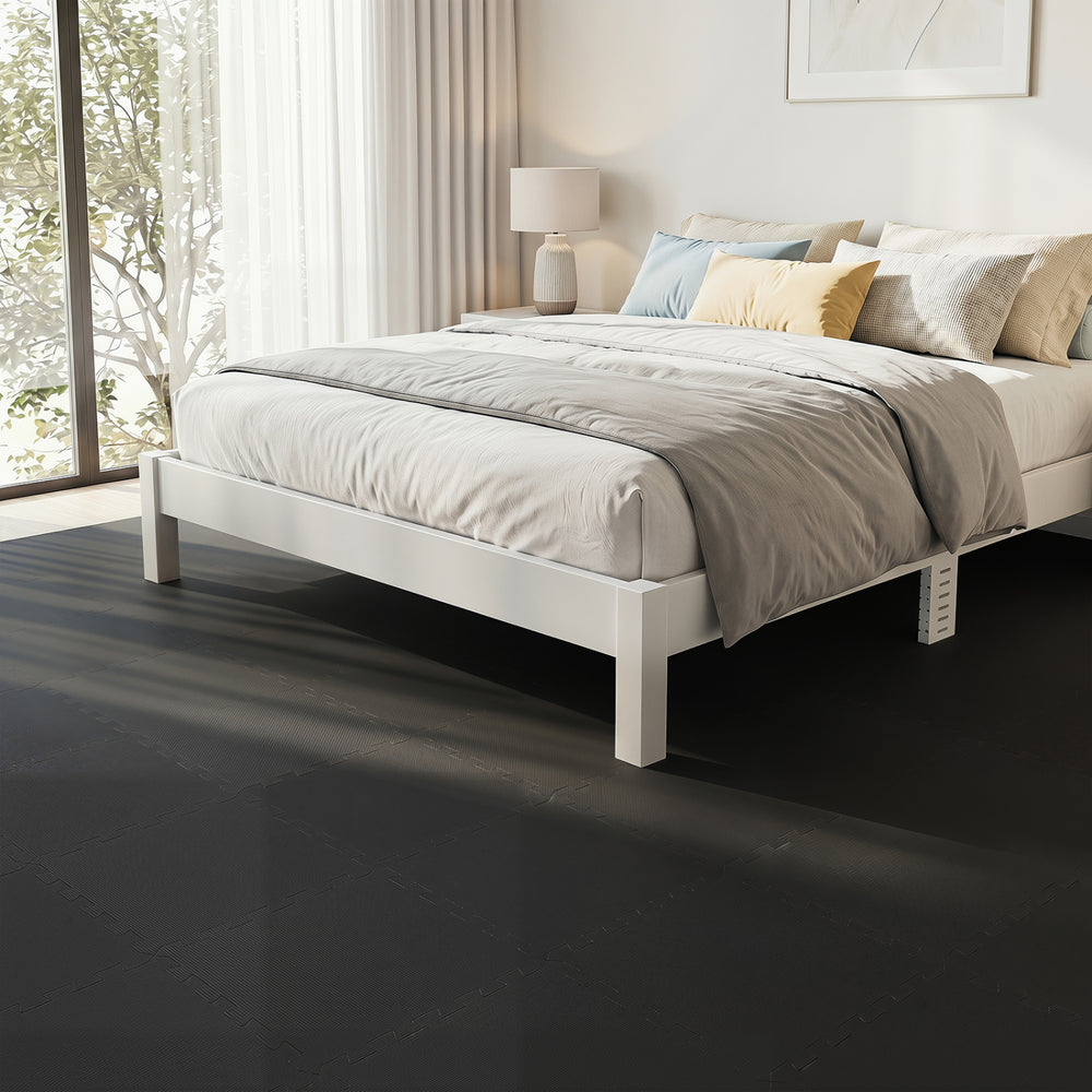 Interlocking black EVA foam floor tiles provide comfort and shock absorption, ideal for home gyms and living spaces.