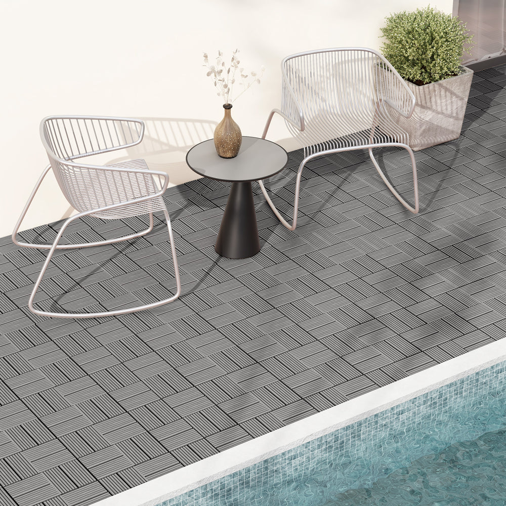 Gray interlocking deck tiles arranged on a patio, showcasing a textured surface for outdoor flooring solutions.