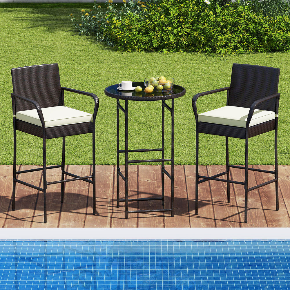 Outdoor bar set featuring two cushioned chairs and a round table, perfect for backyard or poolside relaxation.