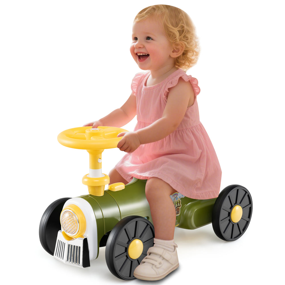 Child riding a green ride-on toy with a steering wheel and train whistle sound, featuring under-seat storage.