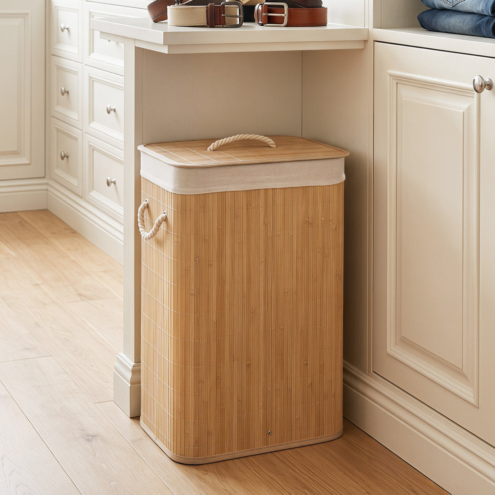 Bamboo clothes hamper with removable liner, portable handles, and natural texture, perfect for laundry rooms and.