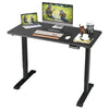 Electric height adjustable standing desk in black with memory controller, providing a spacious workspace for comfort.