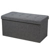 Foldable dark gray storage ottoman with padded seat and roomy interior for blankets, clothes, and shoes. Ideal for any.