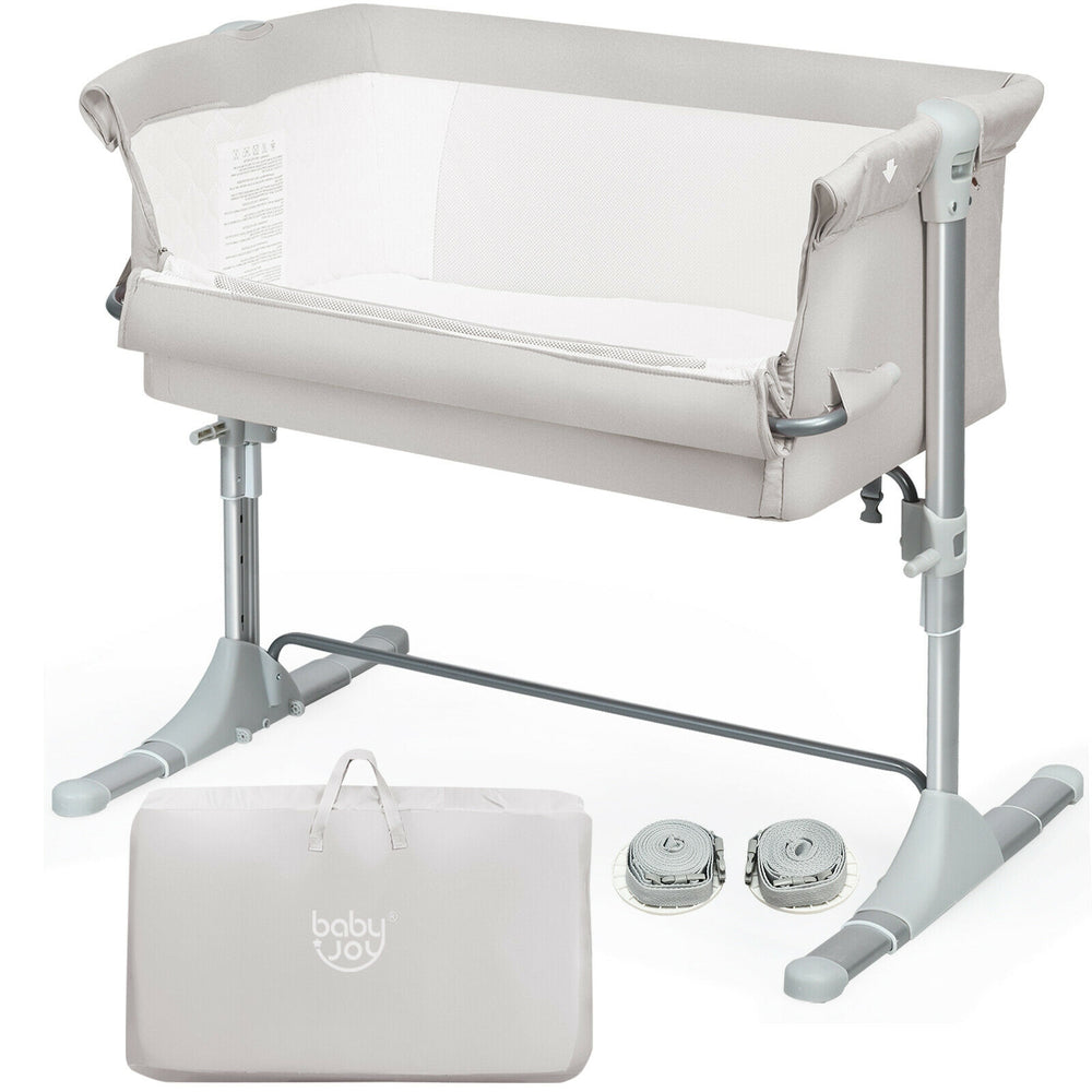 Portable beige baby bedside crib with adjustable heights, detachable sidebar, and carrying bag for easy travel.