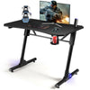 Height adjustable gaming desk with blue LED lights, carbon fiber surface, and sturdy Z-shaped legs for stability.