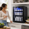 Black 1.55 cu.ft beverage refrigerator with glass door, blue LED lighting, and adjustable shelves in a kitchen setting.