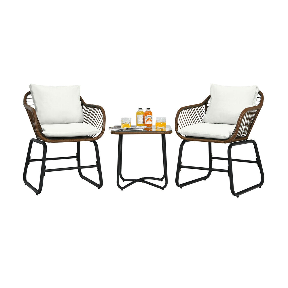Two cushioned armchairs and a glass table in a 3-piece patio rattan bistro set for outdoor relaxation.
