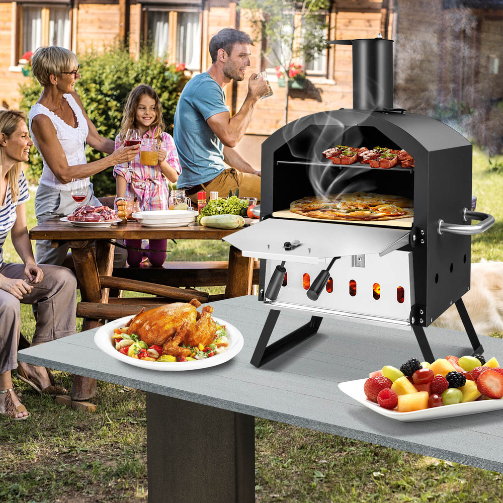 Outdoor pizza oven with foldable legs and anti-scalding handles, cooking pizzas and meals for outdoor gatherings.