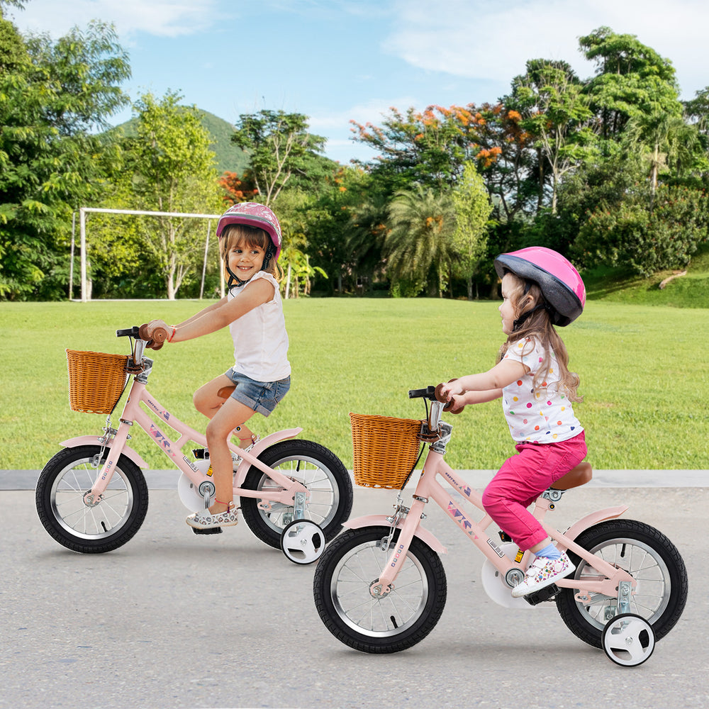 Two children riding 12-inch pink retro bikes with baskets, featuring adjustable heights and safety brakes in a park.