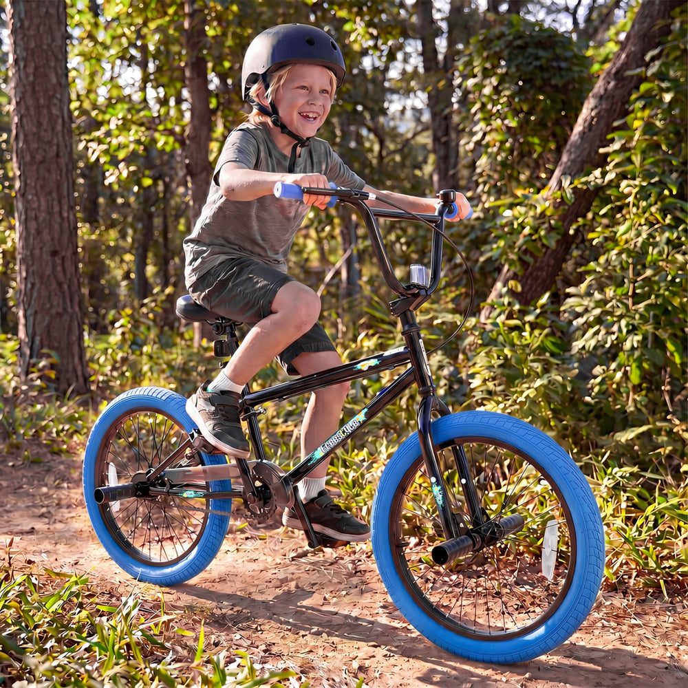 20" trick bicycle for kids with navy frame, 360° steering, adjustable seat, and puncture-proof tires on a forest trail.