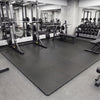 Black 1/2" puzzle exercise floor mats with non-slip texture, ideal for gyms and playrooms, providing impact cushioning.
