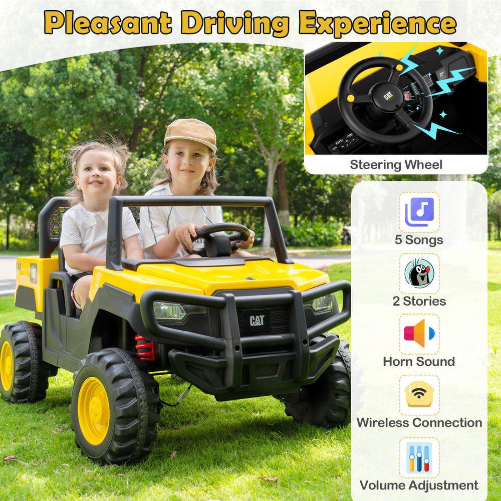 Two children enjoying a ride in a yellow 24V Caterpillar dump truck, featuring a steering wheel and wireless connection.