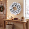 Frosted 24-inch Christmas wreath with 35 color changing LED lights hangs above a festive holiday table.
