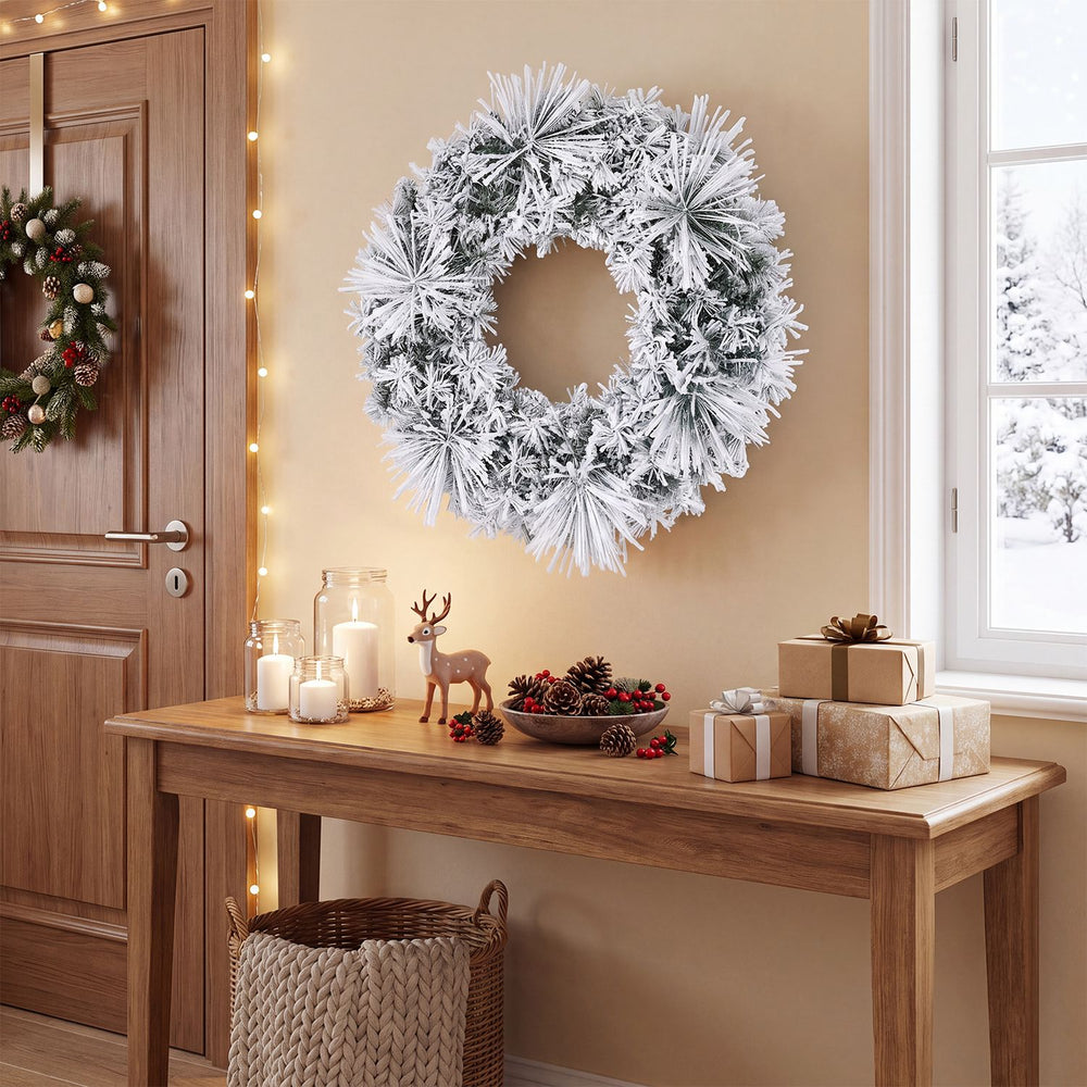 Frosted 24-inch Christmas wreath with 35 color changing LED lights hangs above a festive holiday table.