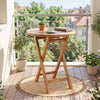 24" round solid teak outdoor folding bistro table with footrest, perfect for small spaces on patios or balconies.